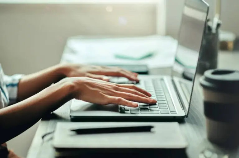 Person typing roofing SEO content on a laptop — professional content writing and marketing services for Canadian roofing companies